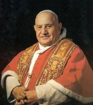 formal portrait of Pope John XXIII in red vestments and white zucchetto, wearing a red-and-gold stole and a kind expression.  His hands are joined on his lap