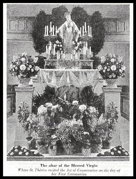Black-and-white photo of the statue of the Blessed Virgin on an altar, surrounded by candles and flowers